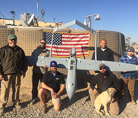 Men posing around an unmanned plane